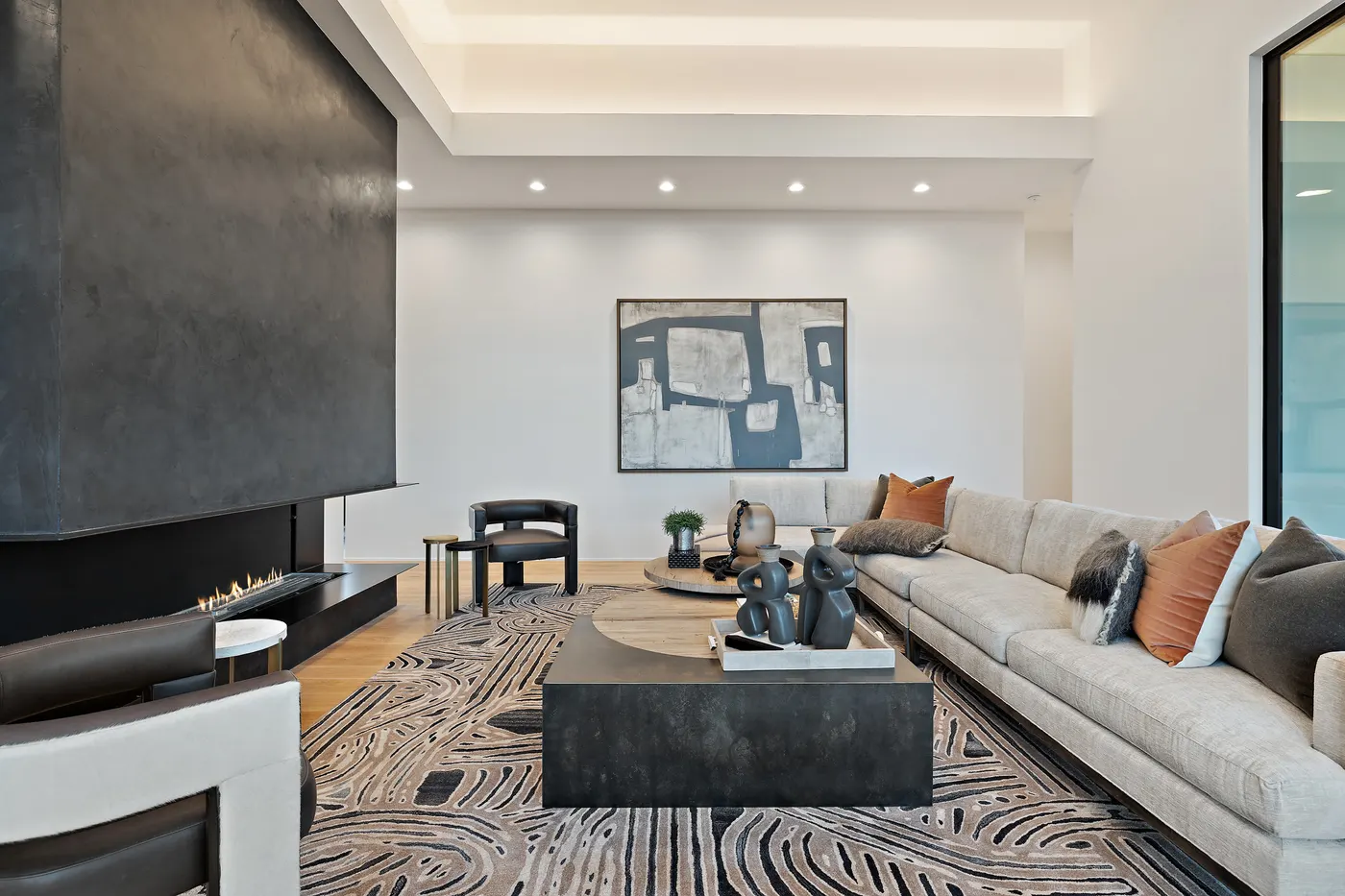 A finished great room with a linear fireplace and full-height glass